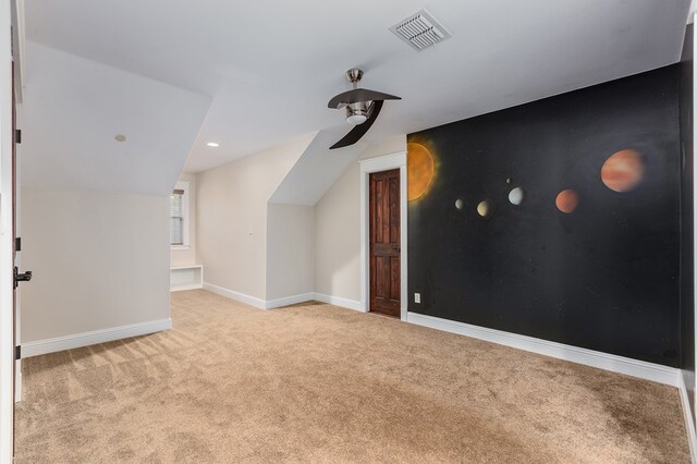 unfurnished bedroom featuring light colored carpet, ceiling fan, lofted ceiling, and ensuite bathroom