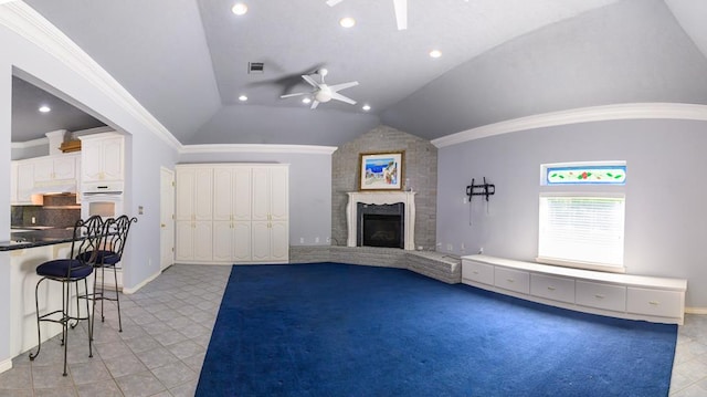 unfurnished living room featuring ceiling fan, light tile patterned floors, visible vents, a brick fireplace, and lofted ceiling