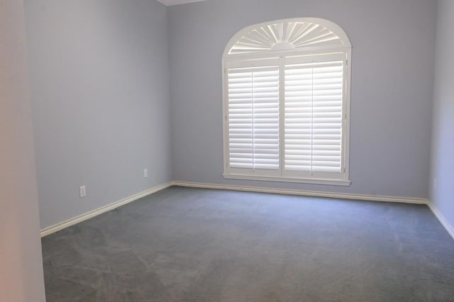 empty room featuring carpet and baseboards