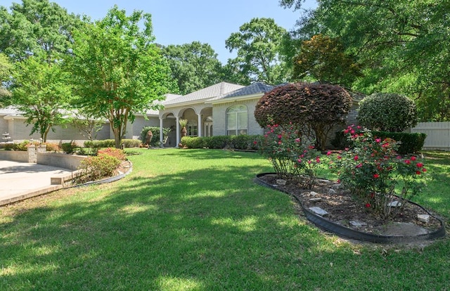 view of front of home with a front yard and fence