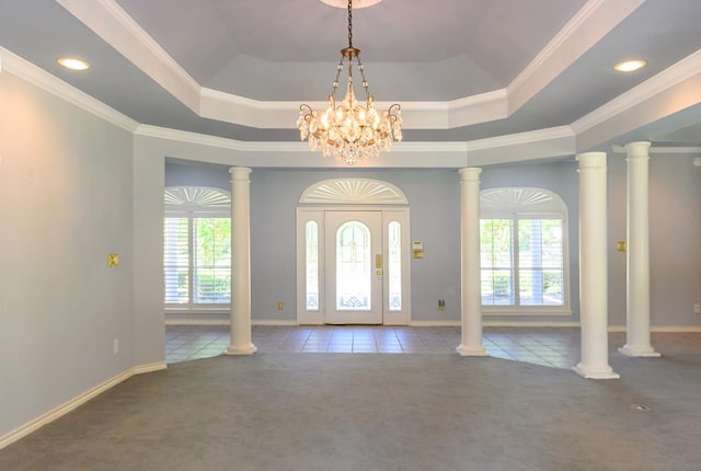 foyer with a raised ceiling, an inviting chandelier, carpet, and a wealth of natural light