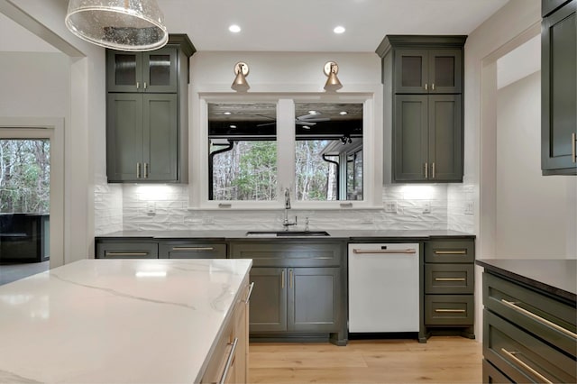 kitchen with a sink, a wealth of natural light, backsplash, and dishwasher