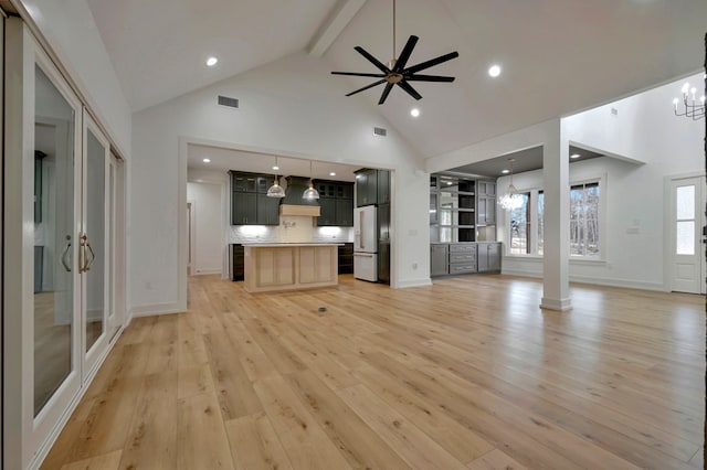 unfurnished living room featuring beam ceiling, high vaulted ceiling, light wood-style flooring, ceiling fan with notable chandelier, and visible vents