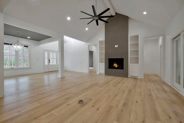 unfurnished living room with beam ceiling, light wood-style floors, high vaulted ceiling, a large fireplace, and baseboards
