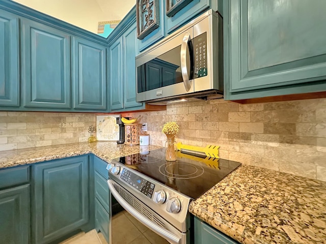 kitchen featuring decorative backsplash, light stone counters, stainless steel appliances, blue cabinetry, and light tile patterned floors