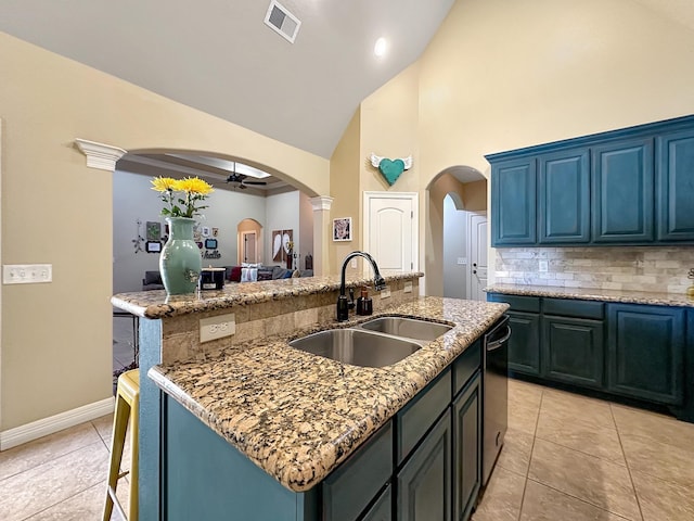 kitchen with ceiling fan, sink, a kitchen island with sink, and high vaulted ceiling