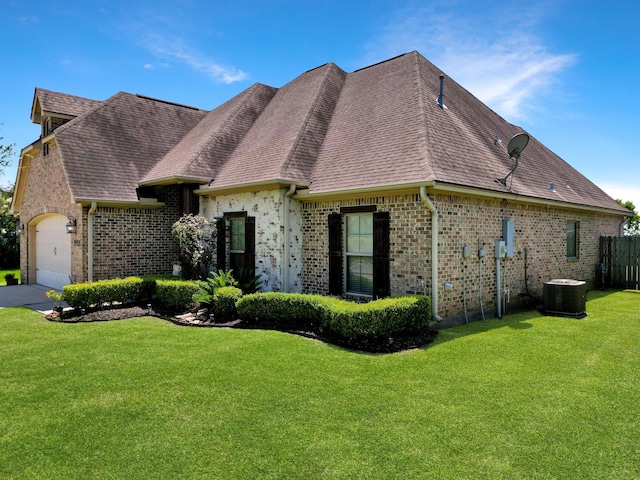 french country inspired facade featuring central air condition unit, a front yard, and a garage