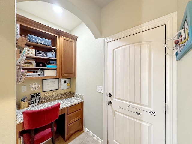 home office featuring light tile patterned floors and built in desk