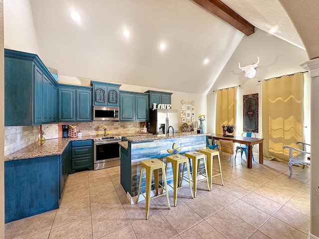 kitchen featuring beam ceiling, a center island, stainless steel appliances, a kitchen breakfast bar, and high vaulted ceiling