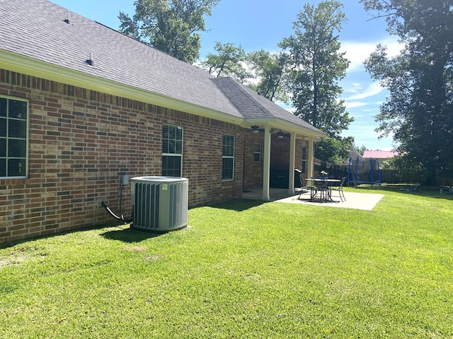 429 Derek Rd, Lufkin, TX 75904 - back of house featuring central AC unit, a patio area, brick siding, and a shingled roof