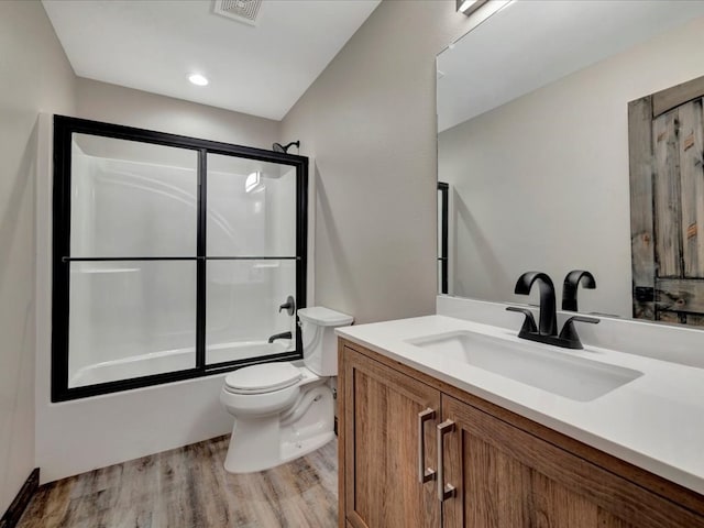 full bathroom with shower / bath combination with glass door, toilet, vanity, and hardwood / wood-style flooring