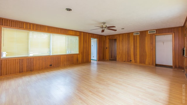 511 1st, Jasper, TX 75951 - spare room with a ceiling fan, light wood-style flooring, plenty of natural light, and wood walls
