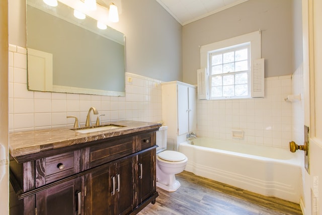 511 1st, Jasper, TX 75951 - bathroom with a bath, tile walls, wood finished floors, vanity, and crown molding