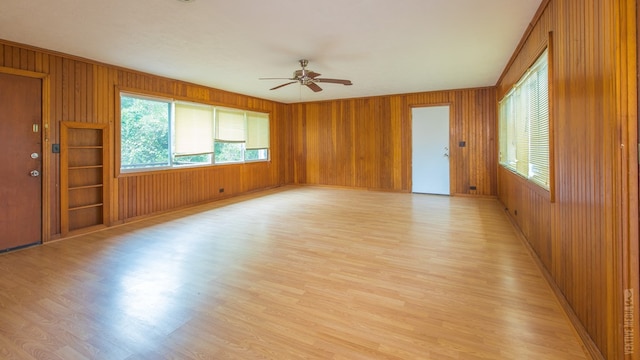 511 1st, Jasper, TX 75951 - unfurnished room featuring light wood-type flooring, plenty of natural light, a ceiling fan, and wooden walls