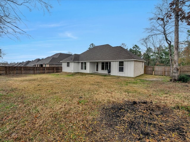 back of property featuring a yard