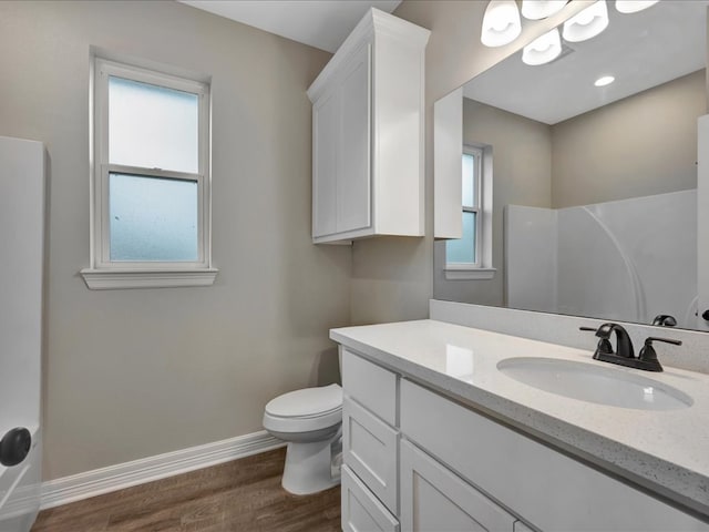 bathroom with walk in shower, vanity, toilet, and hardwood / wood-style floors