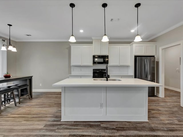 kitchen with hanging light fixtures, black appliances, sink, and white cabinets