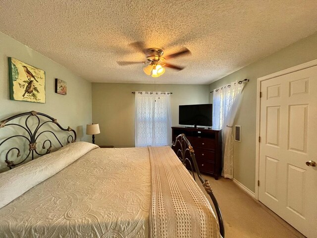 carpeted bedroom with a textured ceiling and ceiling fan