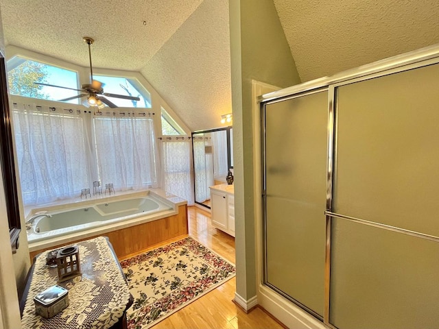 bathroom featuring plus walk in shower, vaulted ceiling, ceiling fan, wood-type flooring, and vanity