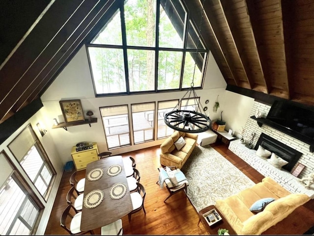 living room with wood ceiling, a fireplace, wood-type flooring, and a high ceiling