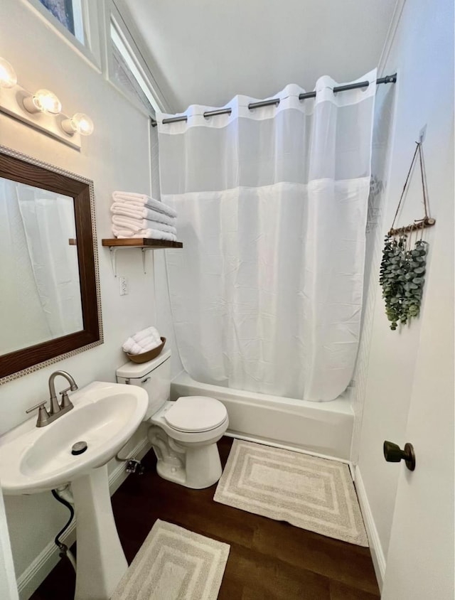 full bathroom featuring hardwood / wood-style floors, toilet, shower / bath combo with shower curtain, and sink