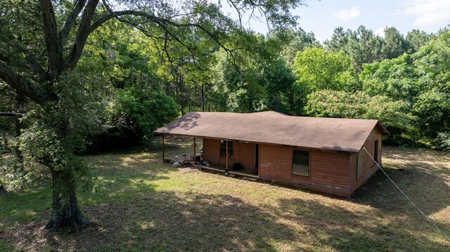 1982 County Road 836, Nacogdoches, TX 75964 - view of home's exterior with a porch, a wooded view, and a lawn