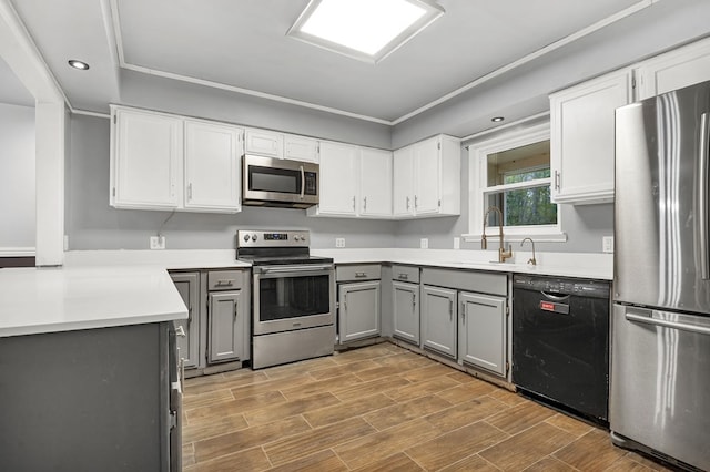 kitchen featuring gray cabinetry, stainless steel appliances, sink, light hardwood / wood-style floors, and white cabinetry