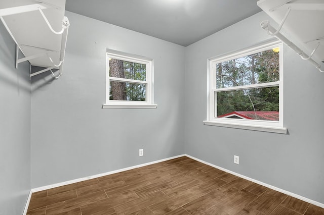 spare room with wood-type flooring and a wealth of natural light