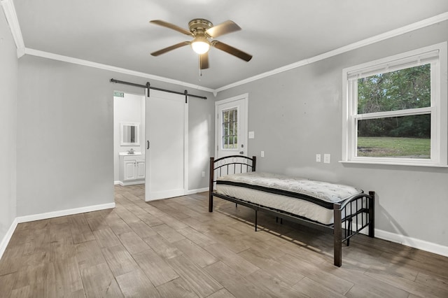 bedroom featuring multiple windows, a barn door, light hardwood / wood-style flooring, and ceiling fan