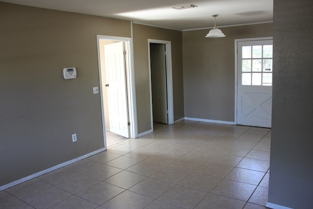 unfurnished room featuring light tile patterned flooring and ornamental molding