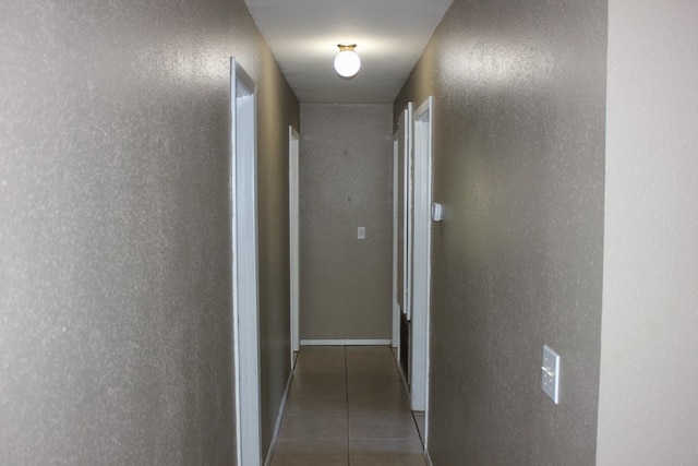 hallway with dark tile patterned flooring