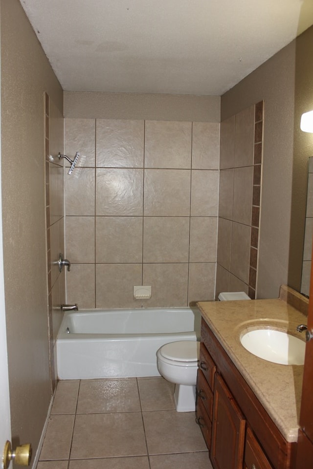 full bathroom featuring tile patterned floors, vanity, toilet, and tiled shower / bath combo