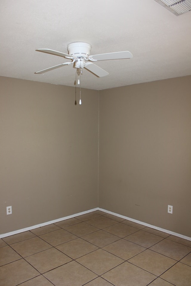 spare room featuring tile patterned floors and ceiling fan