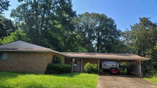 ranch-style house with a carport and a front lawn