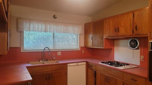 kitchen with white appliances, vaulted ceiling, and sink