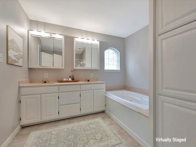 bathroom featuring tile patterned floors, a garden tub, double vanity, and a sink