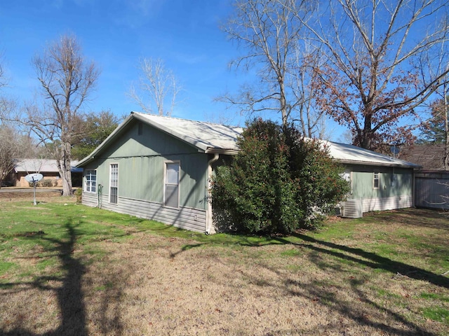 view of side of property with a lawn and central AC unit