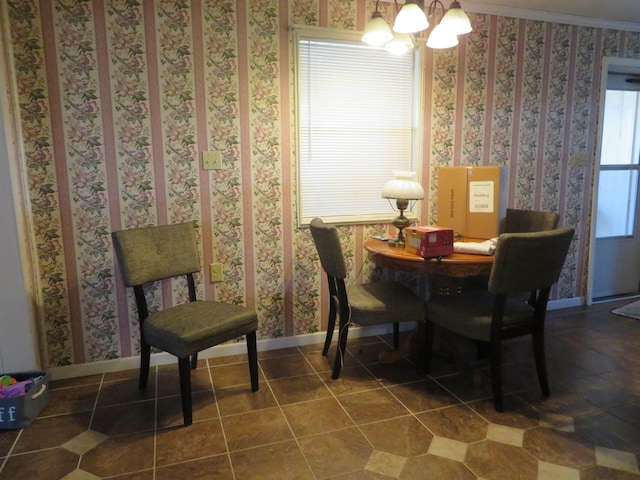 dining room with dark tile patterned flooring, ornamental molding, and an inviting chandelier