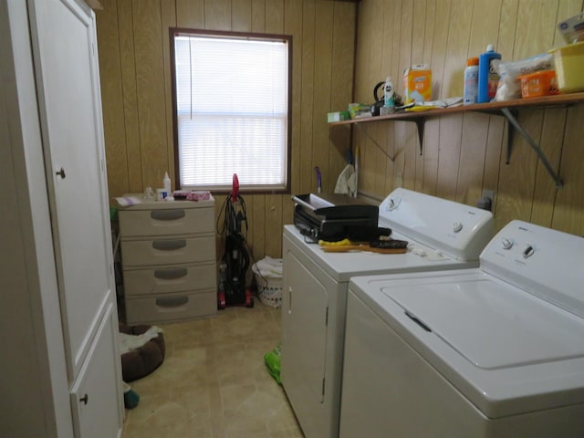 washroom featuring wood walls and washer and clothes dryer