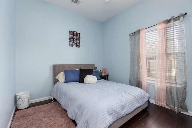 bedroom with dark hardwood / wood-style floors