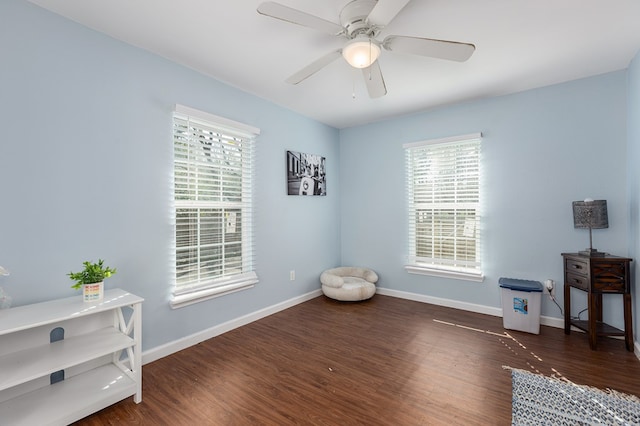 living area with ceiling fan and dark hardwood / wood-style flooring