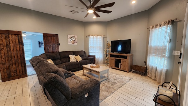 living room featuring ceiling fan, plenty of natural light, and light hardwood / wood-style flooring