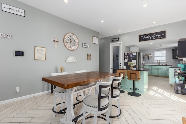 dining area featuring sink and light parquet flooring