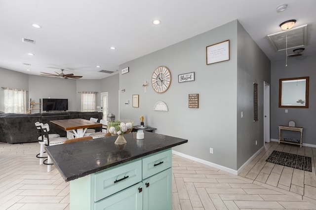 kitchen with light parquet floors, a kitchen island, and ceiling fan