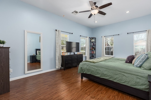 bedroom featuring multiple windows, dark hardwood / wood-style floors, and ceiling fan