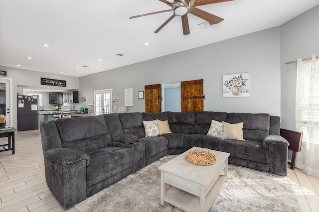 living room featuring lofted ceiling, ceiling fan, and light wood-type flooring