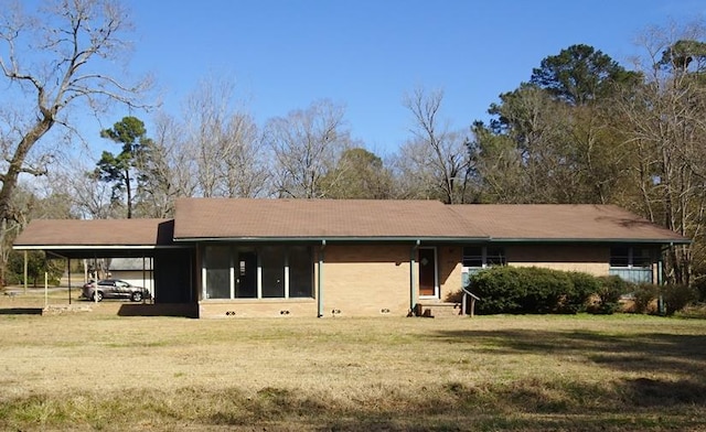 exterior space with a carport and a lawn