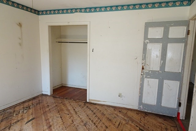 unfurnished bedroom with a closet and wood-type flooring