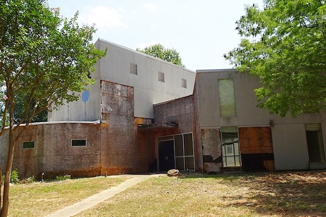 back of house featuring a lawn