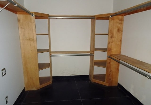 walk in closet featuring dark tile patterned floors